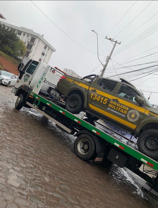 Operador prendendo veículo na plataforma do guincho durante atendimento noturno